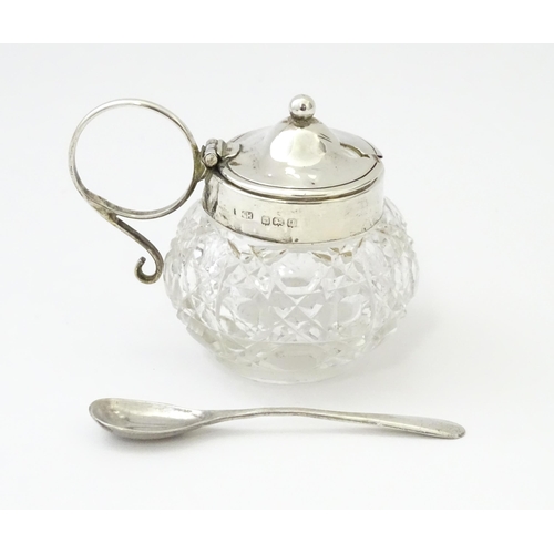 350 - A cut glass mustard pot with silver mounts and handle together with a silver mustard spoon. Both hal... 