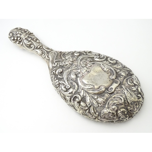 371 - A Victorian silver hand mirror with embossed foliate and mask decoration, hallmarked Chester 1899, m... 