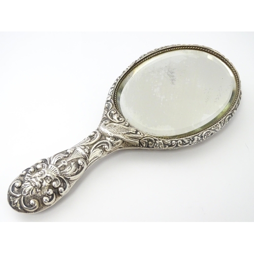 371 - A Victorian silver hand mirror with embossed foliate and mask decoration, hallmarked Chester 1899, m... 