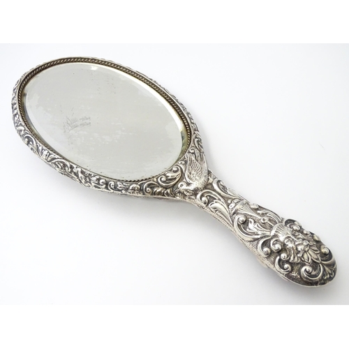 371 - A Victorian silver hand mirror with embossed foliate and mask decoration, hallmarked Chester 1899, m... 