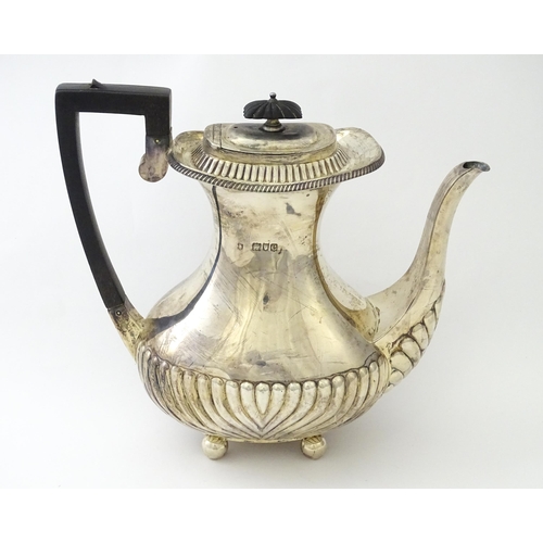 451 - A Victorian silver coffee / hot water pot with fluted decoration standing on four ball feet, hallmar... 