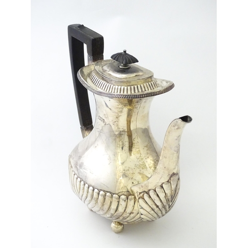 451 - A Victorian silver coffee / hot water pot with fluted decoration standing on four ball feet, hallmar... 