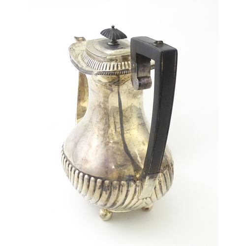 451 - A Victorian silver coffee / hot water pot with fluted decoration standing on four ball feet, hallmar... 