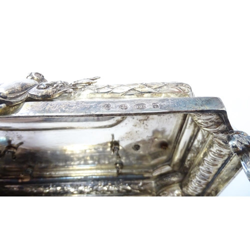 454 - A silver desk standish with Classical muse flanked by two urn formed inkwells and recessed pen well,... 