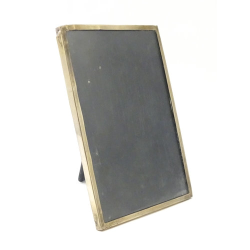 483 - An easel back photograph frame with a silver surround hallmarked Birmingham c. 1958, maker Sanders &... 