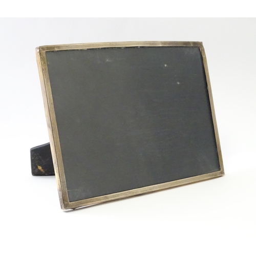 483 - An easel back photograph frame with a silver surround hallmarked Birmingham c. 1958, maker Sanders &... 