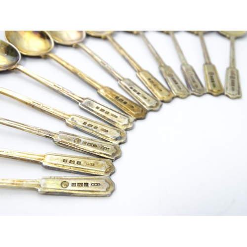 488 - A cased set of twelve silver gilt teaspoons with black enamel detail to reverse of handles and bowls... 