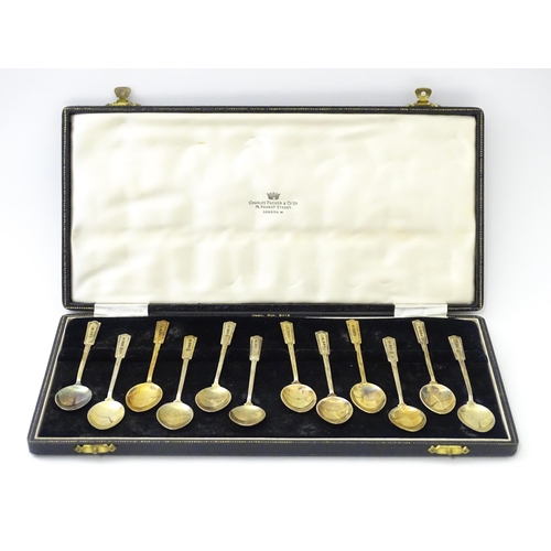 488 - A cased set of twelve silver gilt teaspoons with black enamel detail to reverse of handles and bowls... 