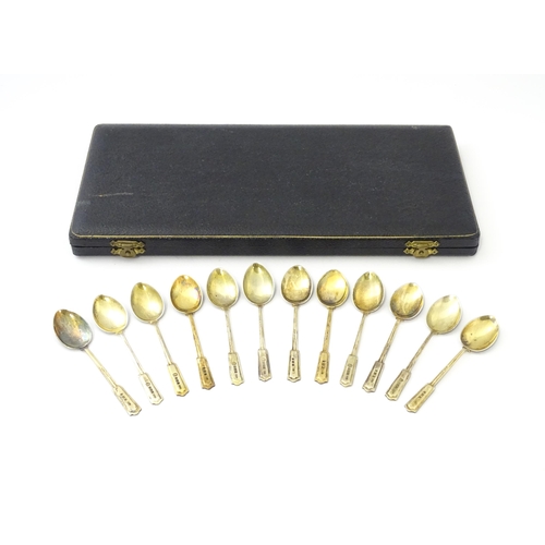 488 - A cased set of twelve silver gilt teaspoons with black enamel detail to reverse of handles and bowls... 