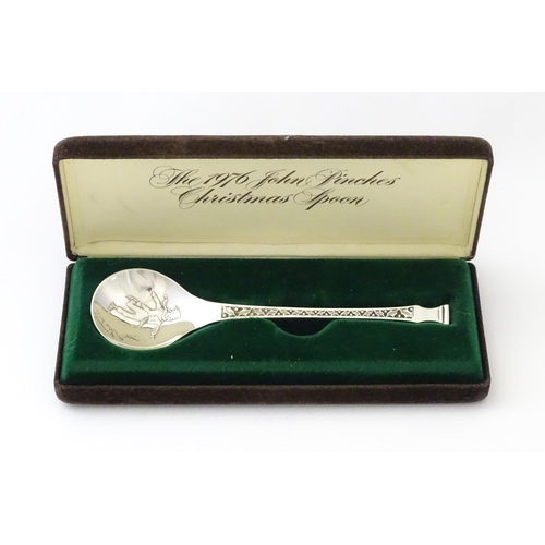 507 - A silver teaspoon 'The 1976 John Pinches Christmas Spoon', hallmarked London 1976, maker John Pinche... 