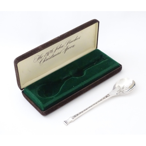 507 - A silver teaspoon 'The 1976 John Pinches Christmas Spoon', hallmarked London 1976, maker John Pinche... 