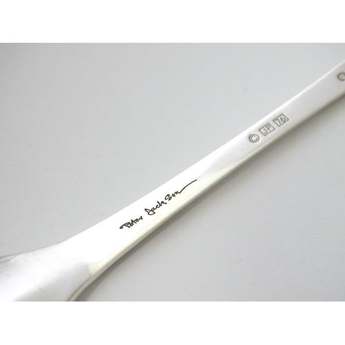 507 - A silver teaspoon 'The 1976 John Pinches Christmas Spoon', hallmarked London 1976, maker John Pinche... 