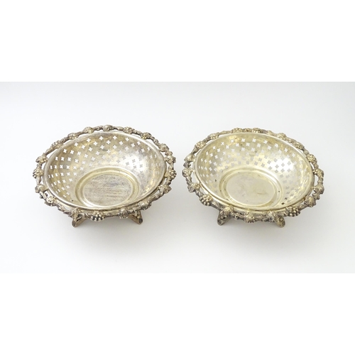 516 - A pair of silver plate dishes of circular form with pierced quatreform detail and fruiting vine deco... 