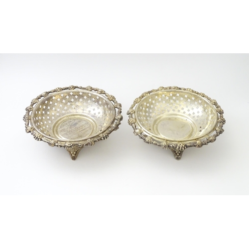 516 - A pair of silver plate dishes of circular form with pierced quatreform detail and fruiting vine deco... 