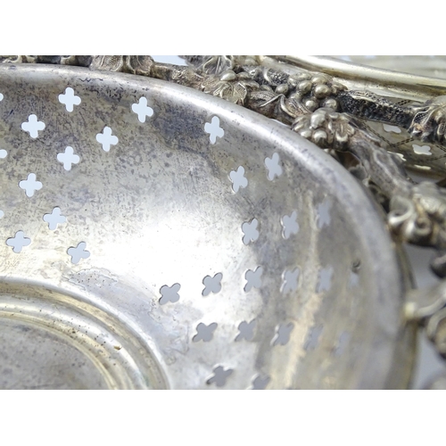 516 - A pair of silver plate dishes of circular form with pierced quatreform detail and fruiting vine deco... 