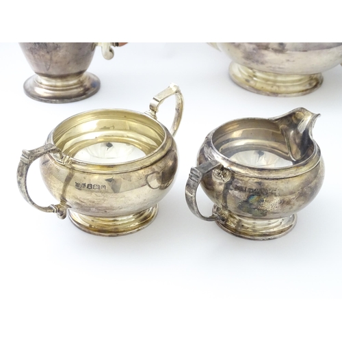 460 - An Art Deco four piece silver tea set comprising teapot, cream jug, sugar bowl and hot water / coffe... 