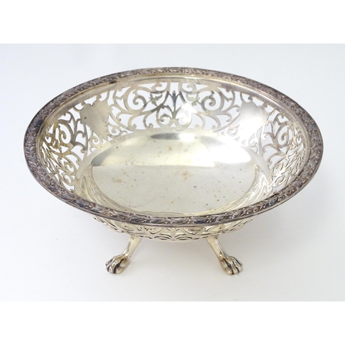 463 - A large silver bon bon dish / fruit dish with pierced scroll detail, standing on four lion paw feet,... 