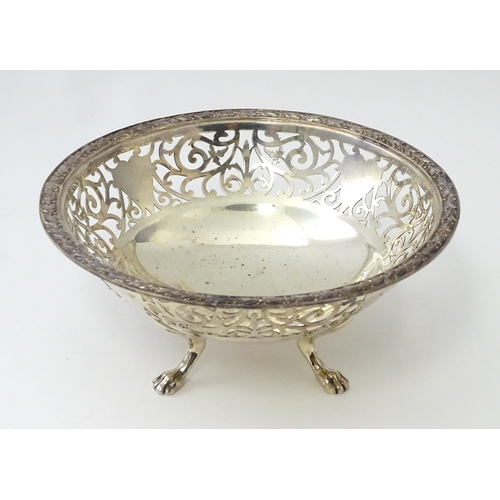 463 - A large silver bon bon dish / fruit dish with pierced scroll detail, standing on four lion paw feet,... 