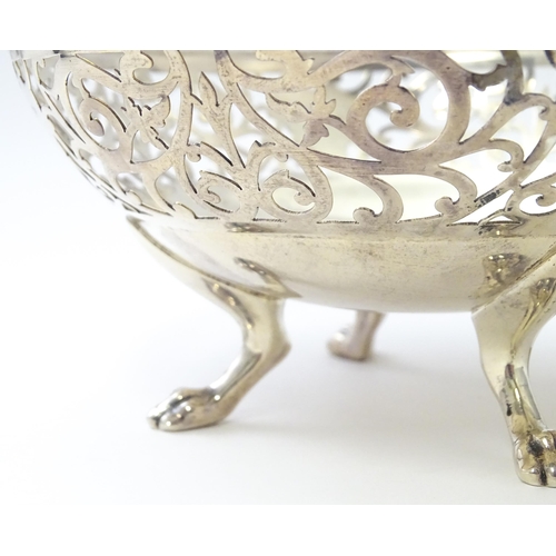 463 - A large silver bon bon dish / fruit dish with pierced scroll detail, standing on four lion paw feet,... 