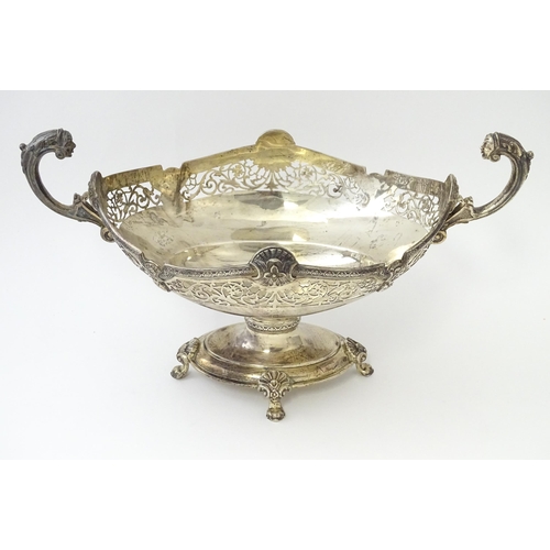 464 - A silver twin handled pedestal bowl with fretwork decoration and figural detail to handles, standing... 