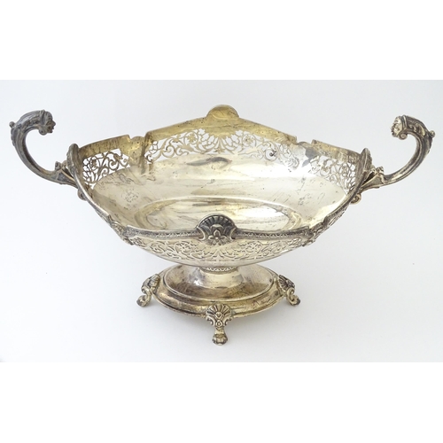 464 - A silver twin handled pedestal bowl with fretwork decoration and figural detail to handles, standing... 