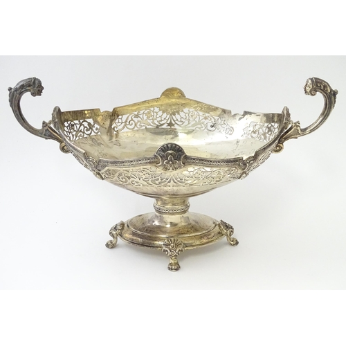 464 - A silver twin handled pedestal bowl with fretwork decoration and figural detail to handles, standing... 