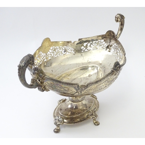 464 - A silver twin handled pedestal bowl with fretwork decoration and figural detail to handles, standing... 