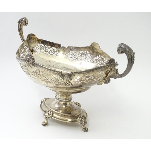 464 - A silver twin handled pedestal bowl with fretwork decoration and figural detail to handles, standing... 