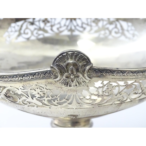 464 - A silver twin handled pedestal bowl with fretwork decoration and figural detail to handles, standing... 