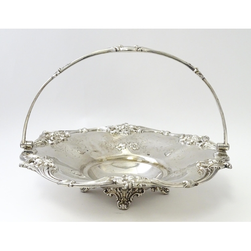 467 - A Victorian silver cake basket with floral and acanthus detail, a swing handle and later inscription... 