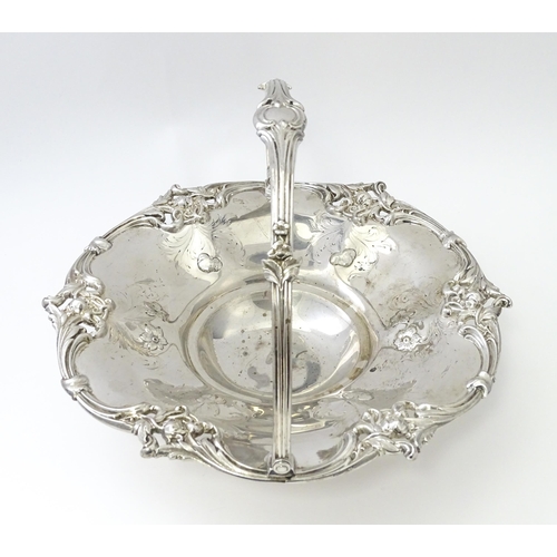 467 - A Victorian silver cake basket with floral and acanthus detail, a swing handle and later inscription... 