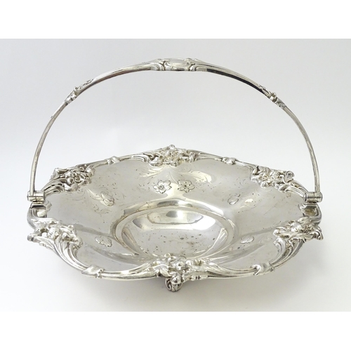 467 - A Victorian silver cake basket with floral and acanthus detail, a swing handle and later inscription... 