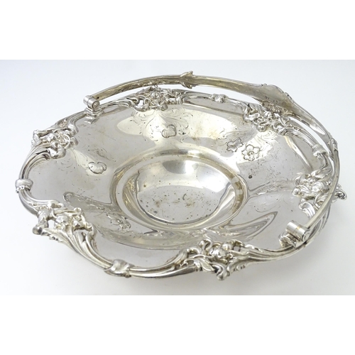 467 - A Victorian silver cake basket with floral and acanthus detail, a swing handle and later inscription... 