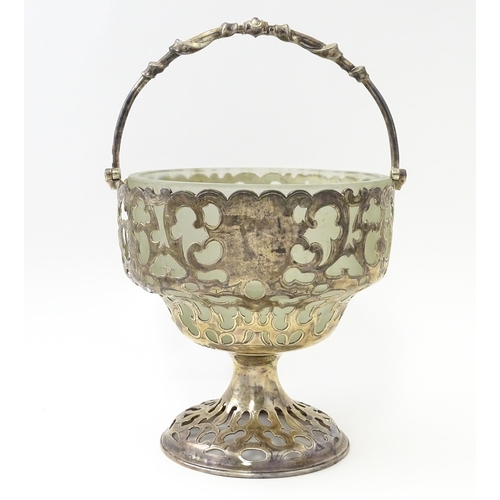 468 - A Victorian silver sugar basket of pedestal form with pierced decoration, swing handle and glass lin... 