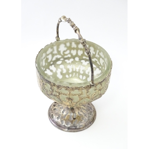 468 - A Victorian silver sugar basket of pedestal form with pierced decoration, swing handle and glass lin... 