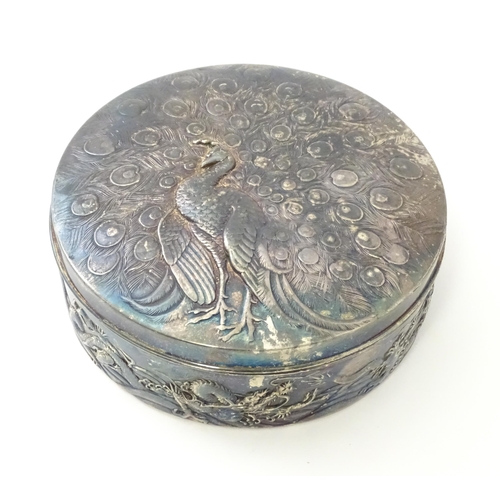 470 - An Art Nouveau silver plate powder box with relief peacock decoration to lid, the body with scrollin... 