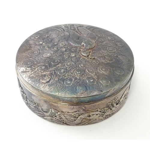 470 - An Art Nouveau silver plate powder box with relief peacock decoration to lid, the body with scrollin... 