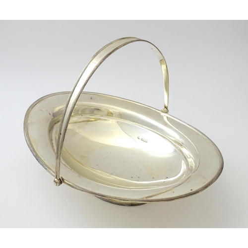 476 - A silver bread / cake basket of oval pedestal form with swing handle, hallmarked Sheffield 1919, mak... 