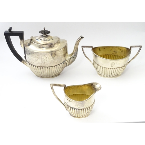 477 - A Victorian silver three piece tea set comprising teapot, cream jug and twin handled sugar bowl with... 