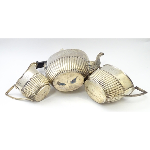 477 - A Victorian silver three piece tea set comprising teapot, cream jug and twin handled sugar bowl with... 