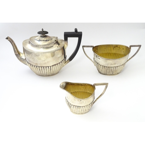 477 - A Victorian silver three piece tea set comprising teapot, cream jug and twin handled sugar bowl with... 