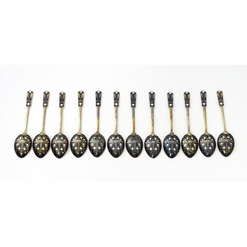 488 - A cased set of twelve silver gilt teaspoons with black enamel detail to reverse of handles and bowls... 