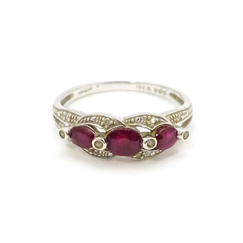 566 - A 9ct white gold ring set with rubies and diamond.  Ring size approx. M 1/2