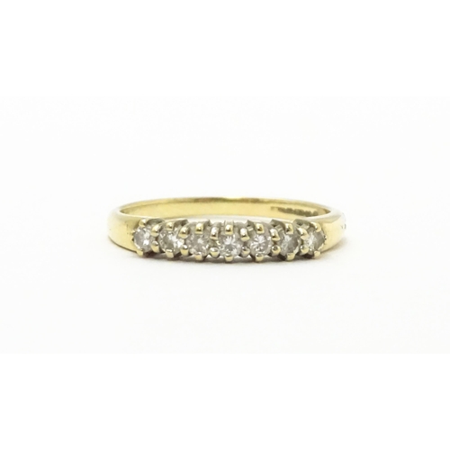 571 - A 9ct gold ring set with seven diamonds in a linear setting. Ring size approx. K 1/2