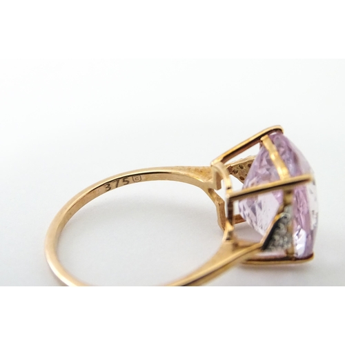 572 - A 9ct rose gold ring set with kunzite flanked by white zircon. Ring size approx. N