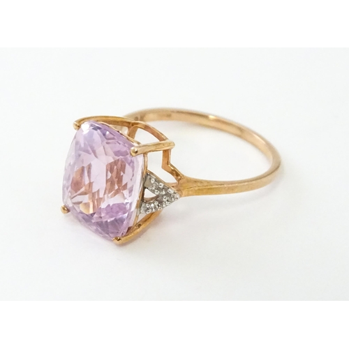 572 - A 9ct rose gold ring set with kunzite flanked by white zircon. Ring size approx. N