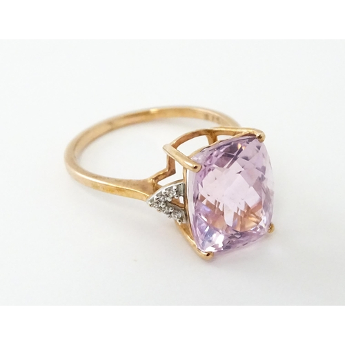 572 - A 9ct rose gold ring set with kunzite flanked by white zircon. Ring size approx. N