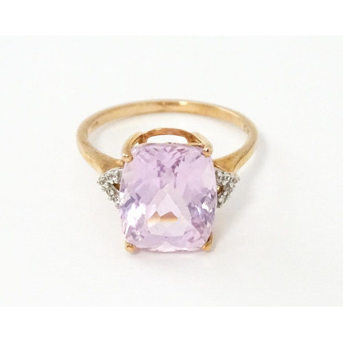 572 - A 9ct rose gold ring set with kunzite flanked by white zircon. Ring size approx. N