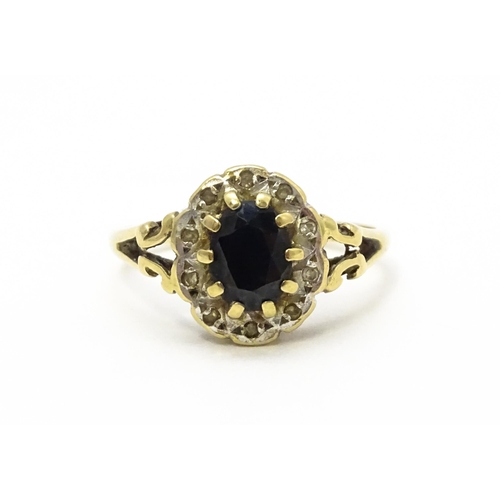 574 - A 9ct gold ring set with central sapphire bordered by diamonds. Ring size approx.  L 1/2