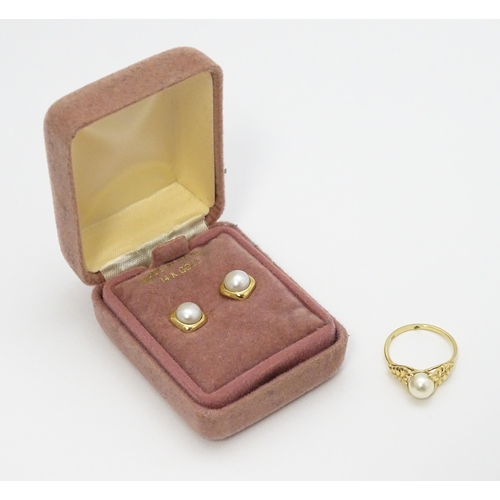 641 - A 14ct gold ring set with central pearl. Ring size approx. M. Together with a pair of stud earrings ... 